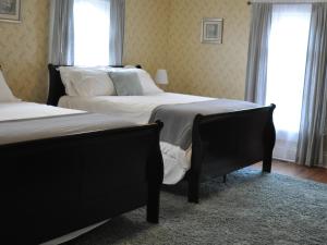 a bedroom with two beds and two windows at The Doctor's Inn in Oxford