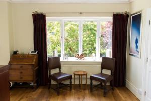 an office with a desk and two chairs and a window at The Grange Guesthouse, Cefn-Coed in Merthyr Tydfil