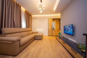 Una sala de estar con un sofá y un televisor. en Central Chic Apartments, en Tirana 37 fotos más