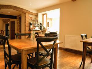 a dining room with a wooden table and chairs at The Plough Inn in Cheltenham