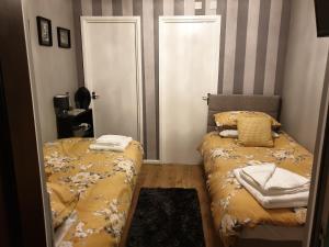 1 dormitorio pequeño con 2 camas y 2 puertas en The Harnser, en Stalham