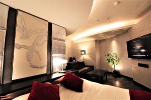 um quarto com uma cama, um sofá e uma cadeira em Hotel Riviera Sagamihara (Adult Only) em Sagamihara