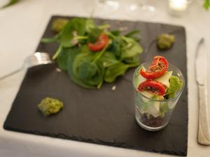 una tabla de cortar negra con una ensalada en una mesa en Domaine La Parpaille en Cucuron