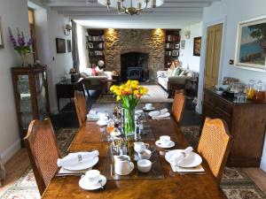 uma sala de jantar com uma mesa e cadeiras e uma lareira em Pengelly Farmhouse B&B em Truro