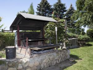 - un barbecue avec un toit sur un mur en pierre dans l'établissement Le Domaine du Plantier, à Saint-Hilaire-de-la-Côte