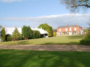 une grande maison avec une pelouse verte en face de celle-ci dans l'établissement Park Hill Hotel, à Lowestoft