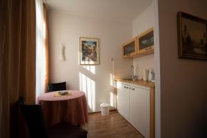 a small room with a table and a kitchen at Pension am Dom in Schwerin +2 photos