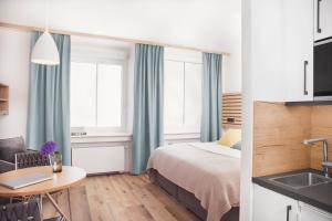 Habitación de hotel con cama, mesa y lavabo en ZÄHLWERK Apartments, en Pfaffenhofen an der Ilm