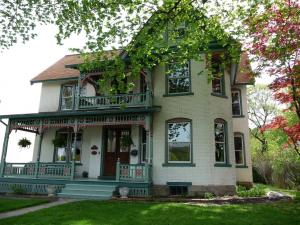 a large house with a porch on a lawn at Victorian Loft Bed and Breakfast in Clearfield