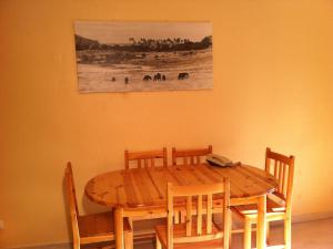 una mesa de madera con sillas y una pintura en la pared en Paradisier Apartment Mougins, en Mougins
