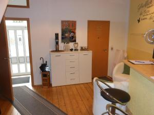 a room with a kitchen with a counter and a chair at Pension Am Werder in Bernburg