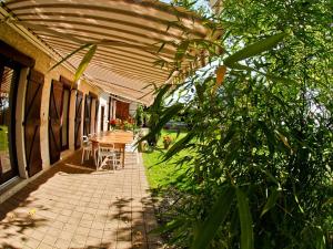 un patio con mesa y sillas bajo una sombrilla en Le Domaine du Plantier, en Saint-Hilaire-de-la-Côte