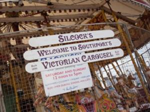 a bunch of signs on a cage in a market at The Heidi Bed & Breakfast in Southport