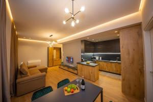 Una cocina y una sala de estar con una mesa y un sofá. en Central Chic Apartments, en Tirana