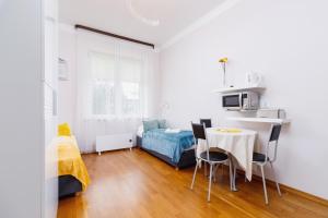 a small white room with a table and a bed at Studio Krowoderska Kraków by Renters in Krakow