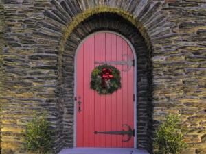 a red door with a wreath on it at The Manor on Front in Harrisburg