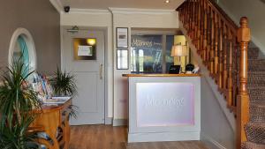 un negozio con un cartello in un corridoio con una scala di The Moorings Hotel & Seafood Restaurant a Portmagee