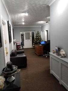 a living room with a christmas tree and a couch at The Mayfair Lodge & Family Suite in Hartlepool