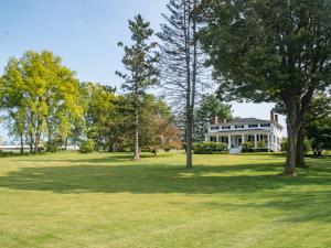 uma casa branca com árvores no quintal em The Neighbour House B&B em Long Valley