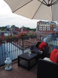 un patio con tavolo e ombrellone su un balcone di Suite sul fiume a Parma