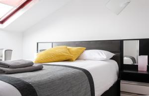 una camera da letto con un grande letto con un cuscino giallo di Central Hoxton Shoreditch a Londra