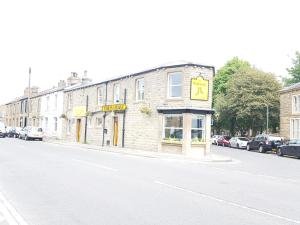 a building on the side of a street with cars parked at The Railway in Skipton