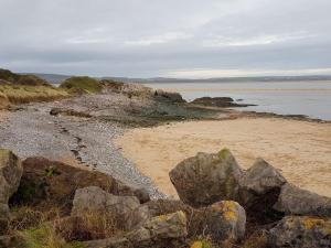 a beach with some rocks and the water at The Pavilion Guest House in Millom