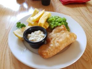 a plate of food with fish and chips and dip at The Railway in Skipton