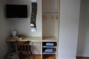 a room with a desk with a television and a chair at The Plough Inn in Swindon