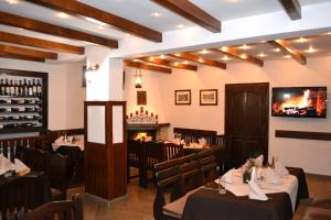 a restaurant with tables and chairs and a fireplace at Family Hotel and Restaurant Varosha 2003 in Lovech