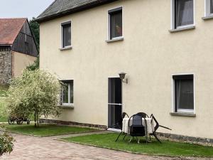 a table and chairs sitting outside of a house at -am Fuß zum Zittauer Gebirge- in Hainewalde