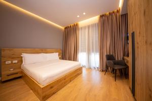 Schlafzimmer mit einem Bett, einem Schreibtisch und einem Stuhl in der Unterkunft Central Chic Apartments in Tirana
