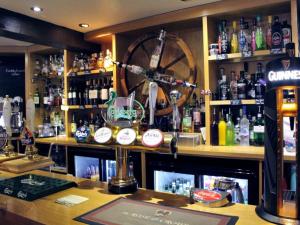 un bar con una bicicleta en la pared detrás en The Rose and Crown en Thorpe le Soken