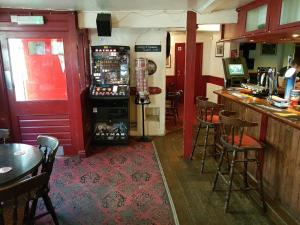 a bar in a restaurant with a red door at The Railway Inn in Dawlish
