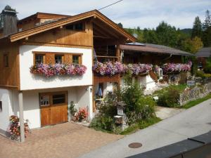 una casa con cajas de flores a un lado. en Badhaus en Achenkirch
