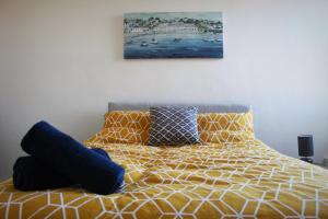 a bed with pillows and a painting on the wall at The Place by the Sea in Blackpool