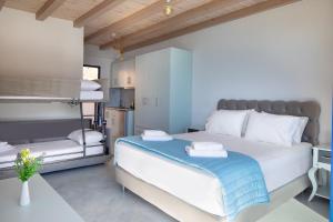 a bedroom with a bed with a blue blanket on it at Molos Apartments in Loutro