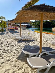 a group of chairs and umbrellas on a beach at Beautiful apartment for rent in Quinta do Lago with excellent resort facilities close to lake and beach. in Quinta do Lago +19 photos