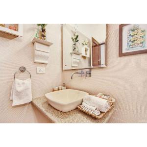 a bathroom with a sink and a mirror and towels at On The House in New Delhi