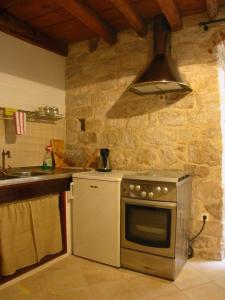 een keuken met een fornuis en een wastafel bij Rooms Livia in Trogir