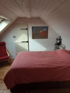 una camera da letto con letto rosso in mansarda di Vakantiewoning De Wilg - rustig gelegen a Geraardsbergen
