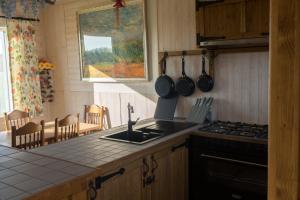 a kitchen with a sink and a stove top oven at Vakantiewoning De Wilg - rustig gelegen in Geraardsbergen