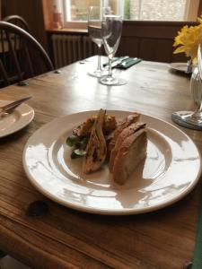 a white plate with a sandwich on a wooden table at The Star and Garter in East Dean