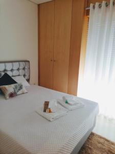 a bed with a tray of food on it at Apartamento Praia do Relógio in Figueira da Foz