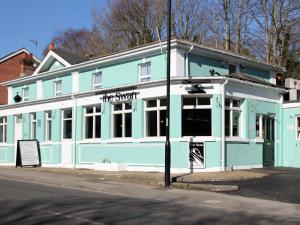 un edificio azul y blanco en la esquina de una calle en The Swan Inn, en Southampton