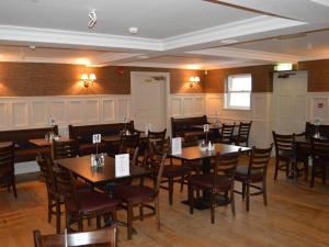 een eetkamer met houten tafels en stoelen bij The Ryandale Inn in Dungannon