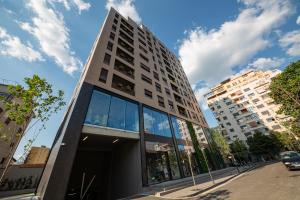un edificio alto con ventanas de cristal en una calle en Central Chic Apartments, en Tirana