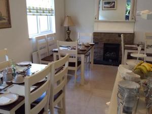 uma sala de jantar com uma mesa e cadeiras e uma lareira em The Vee Guest Accommodation em Waterford