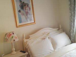 Un dormitorio con una cama blanca y una foto en la pared en The Vee Guest Accommodation, en Waterford