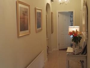 um corredor com um vaso de flores sobre uma mesa em The Vee Guest Accommodation em Waterford